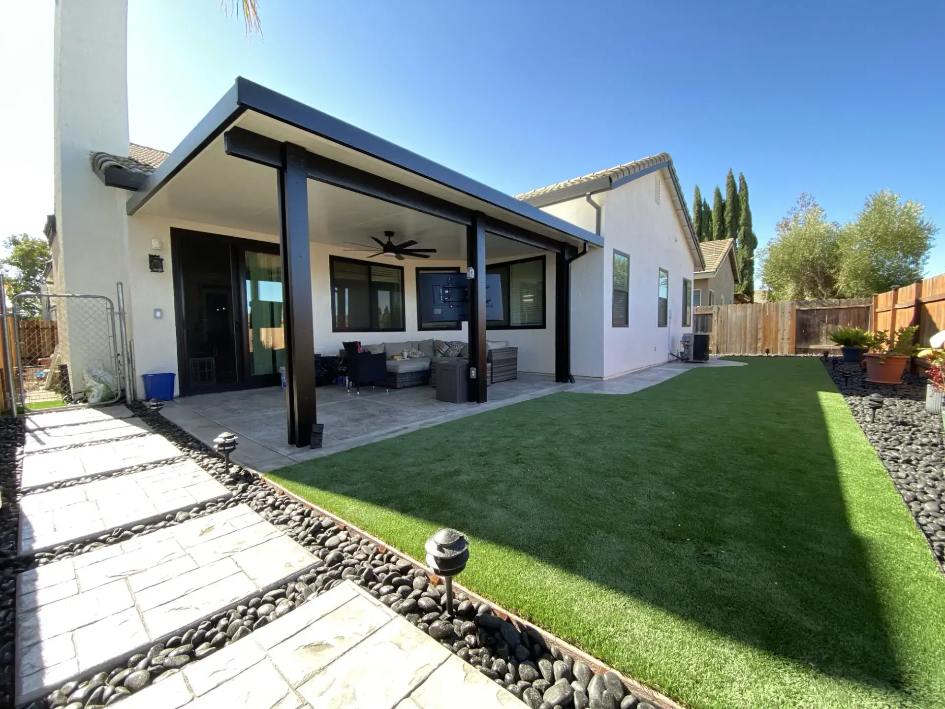 Finished J Brothers covered patio opening to lawn and a concrete walkway
